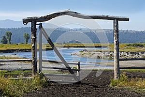 Ranch entry gate in pasture, bank of Buffalo Fork River, Wyoming photo