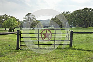 Ranch gate with pasture and trees in the Texas Hill Country photo