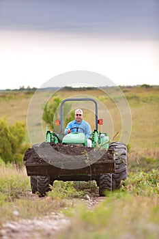 Rancher hauls dirt with tractor
