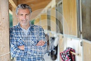 rancher posing near stables