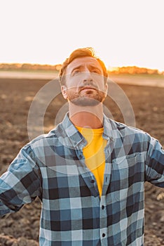 Rancher in shirt looking up while