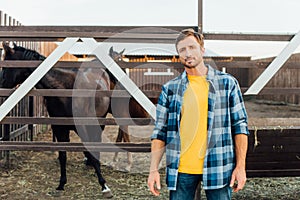 Rancher in shirt standing near corral