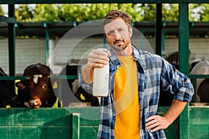 Rancher in shirt standing near cowshed