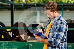 Rancher in shirt writing on clipboard