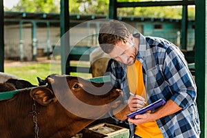 Rancher in shirt writing on clipboard