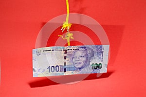 Rand bank note hanging by a thread