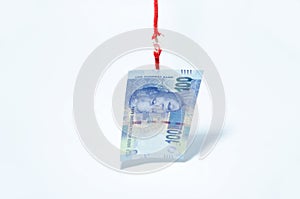 Rand curreny bank note hanging by a thread