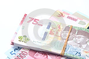 Random Layout Photo Rupiah Paper Money, 10000, 50000, 100000 and 75000 at Brown Envelope at White Background