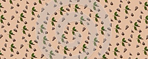 Random pieces of natural chocolate with fresh mint in a pattern on the beige pastel background . Top view , continous pattern .