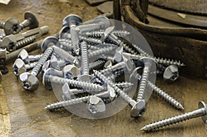 Random pile of hexagonal threaded steel bolts or screws.