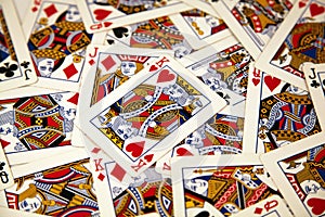 Random playing cards of kings, queens and jacks together forming a background