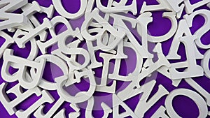 random white wooden alphabet letters on purple background