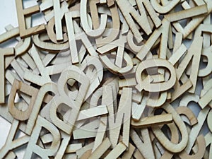 Random wooden alphabet letters top view on purple background