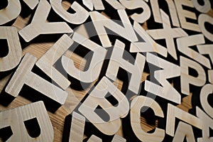 Random wooden block letters lying on wooden background