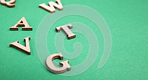 Random wooden letters isolated on green