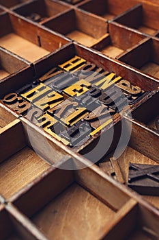 Random wooden letters in a wooden letterpress box