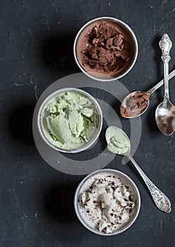 Range of coconut milk ice cream with chocolate, matcha powder, chocolate chips and vanilla. On a dark background, top view. Gluten