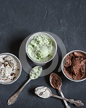 Range of coconut milk ice cream with chocolate, matcha powder, chocolate chips and vanilla. On a dark background, top view.