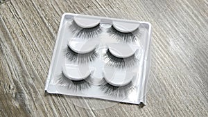 A range of long black false eyelashes for professional makeup in a white box. Makeup at a stylist in a beauty salon