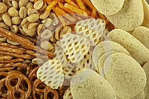 Range of salty snacks, as background. Pretzels, potato chips, crackers and salty straw photo