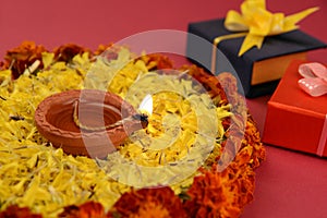 Rangoli of Marigold flowers with Diwali Diya and Gift boxes