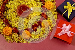 Rangoli of Marigold flowers with Diwali Diya and Gift boxes