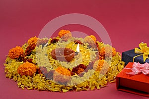 Rangoli of Marigold flowers with Diwali Diya and Gift boxes