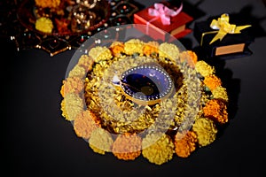 Rangoli of Marigold flowers with Diwali Diya and gift boxes for festival