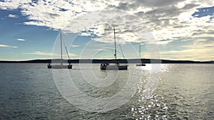 Ranks from yachts of participants of a regatta goes on a start point at sunset, is a sailing race at Croatia, reflection