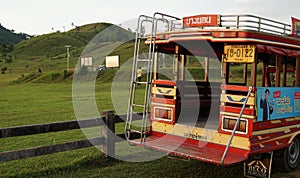 Traditional unique pick up truck for transportation with advertiser in Myanmar language with grass hill background