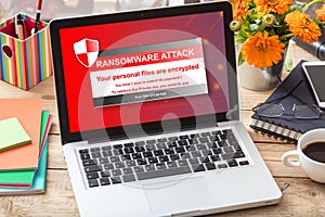 Ransomware attack message on a laptop screen on an office desk photo