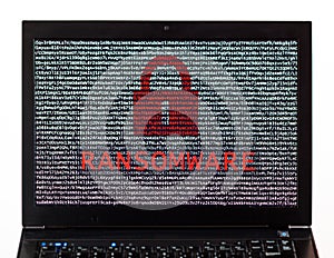 Ransomware text with red lock over encrypted text on a laptop sc