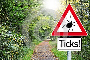 Raod sign in the forest with the german word for beware of ticks - Achtung Zecken photo