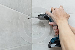 Rapairman drilling ceramic tile on a wall