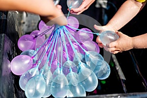 Rapid filling self sealing water balloons being inflated with a hose. photo