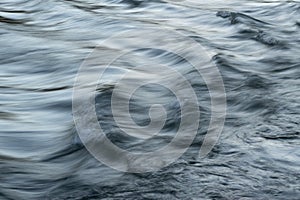 Rapid water flow in mountain stream with silky surface and motion blur
