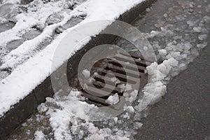 4 - Rapidly melting snowfall runs into roadside surface drain photo