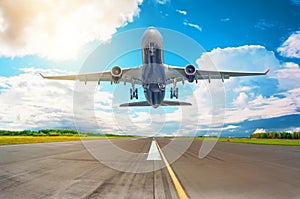 Rapidly plane taking off runway, airstrip with marking on blue sky with clouds background. Travel aviation concept