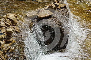 Rapids and waterfalls on the fast mountain river. Close-up of fast flowing water and stones. Olkhovka river in Kislovodsk