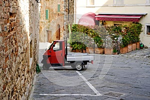 Rapolano Terme, Tuscany, Italy. Ape PIaggio red parked in the old town photo