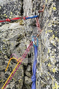 Rappel stance, safety loop and rappel rope while preparing for rappelling from the rappel anchor after finishing climbing in the photo