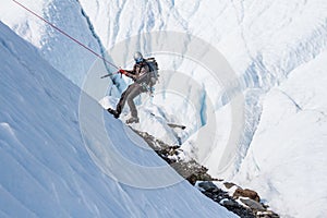Rappelling down an icy slope on a glacier in Alaska