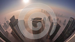 Rare early morning winter fog above the Dubai Marina skyline and skyscrapers lighted by street lights aerial night to