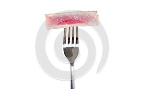 Rare fried tuna steak on a fork close-up. Isolated on white background