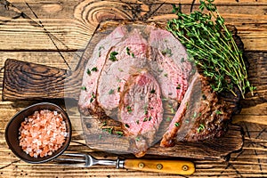 Rare slices of Roast beef sirloin tri tip steak bbq on a wooden cutting board. wooden background. Top view