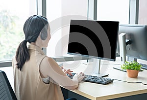 Rare view of attractive and smile young asian customer servicer woman wearing headset in modern creative meeting working office