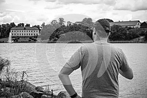 Rare view of the a man looking away over a lake