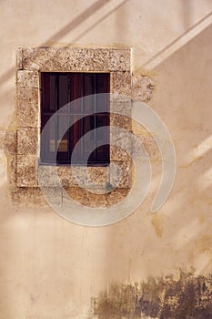 Rare vintage window of old building with lines of shadows on the wall. Copy space.