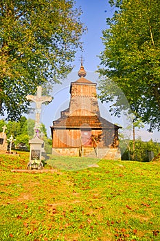 Crucifix in the front of the Wooden church of Saint Michael the Archangel in Prikra during summer sunset