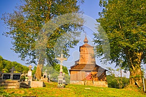 Crucifix in the front of the Wooden church of Saint Michael the Archangel in Prikra during summer sunset